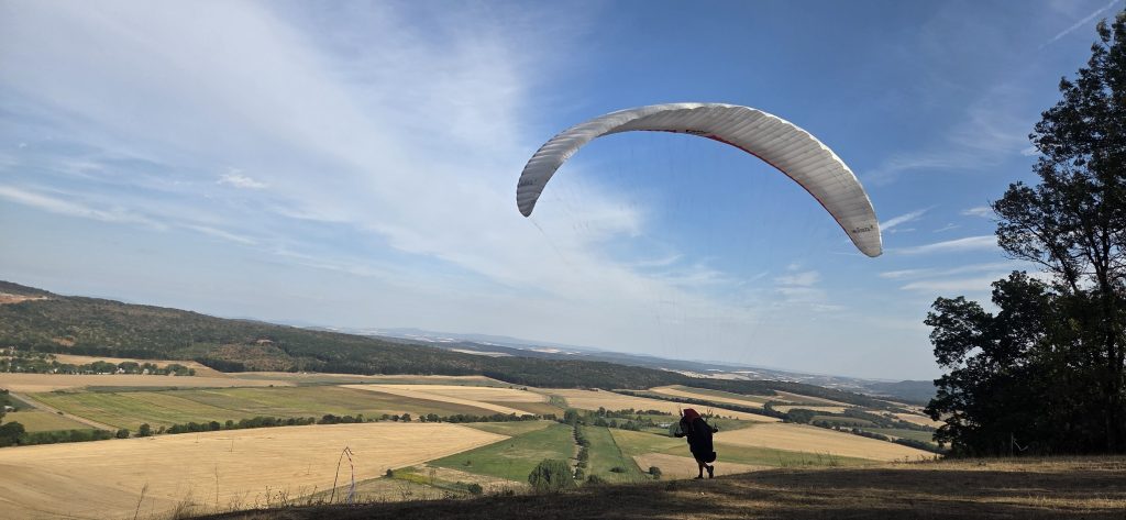 Siklóernyős pilóta startol a tardosi hegyoldalból