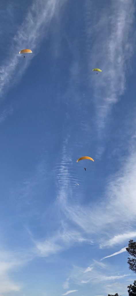 Színes siklóernyők repülnek magasan a kék tardosi égben